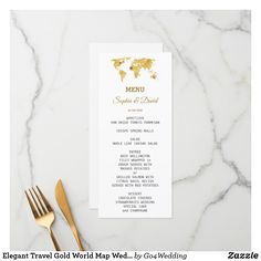 a menu card with gold foil on it next to a fork and knife, along with a map of the world