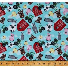 a blue fabric with farm animals and tractors on it, in front of a ruler