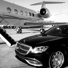 a black car parked in front of an airplane