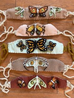 five butterfly hair clips on a wooden surface with string attached to the ends and two butterflies hanging from them