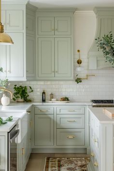 a kitchen with green cabinets and white counter tops, an area rug on the floor