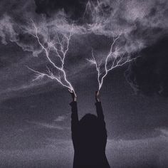 a person holding their hands up in the air with lightning coming out of them,