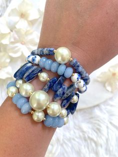 This bracelet stack features a variety of beads and gemstones in complementary hues of blue, white, ivory, and gold. These bracelets are made with stretch elastic. Please take care not to overextend your bracelets. To wear, gently roll them off and on your wrists. Each bracelet comes in a standard size of 7 inches. If you need a slightly smaller or larger size, please message me prior to purchasing and I will be happy to accommodate you. All bracelets are made to order. Each style is sold separa Floral Bead Bracelet, Gemstone Stretch Bracelets, Bead Bracelet Stack, Gems Bracelet, Beads Bracelet Design, Blue Sodalite, Silver Jewelry Design, Lovely Jewellery, Ceramic Beads