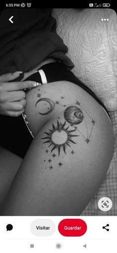 a woman's thigh with sun and moon tattoos on the side, next to an iphone