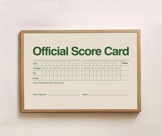 an official score card mounted on a wall above a wooden framed sign that reads,'official score card '