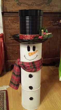 a snowman made out of pails sitting on the floor