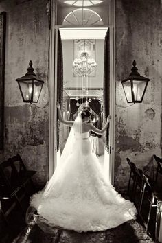 a bride and groom standing in front of an open doorway