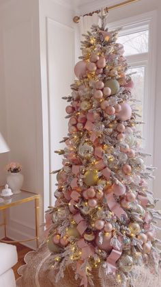 a white christmas tree with pink and gold ornaments