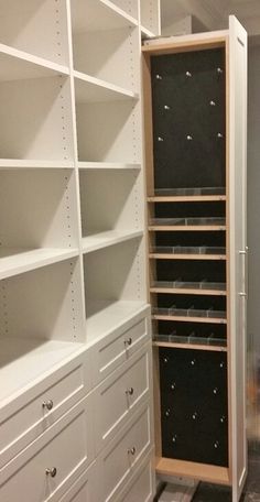 an empty closet with white shelving and drawers