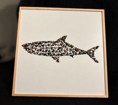 a paper cut shark is displayed in a wooden frame