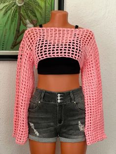 a female mannequin wearing shorts and a pink crop top with holes on it