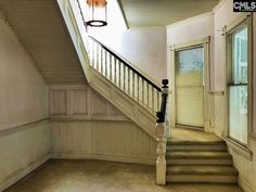 an empty room with some stairs and a light hanging from the ceiling over it's doorway