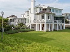 a large white house sitting on top of a lush green field