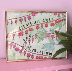 a pink shelf with a painting and potted plant