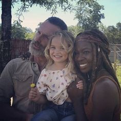 a man, woman and child are smiling for the camera