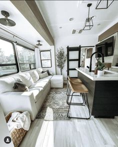 a living room filled with furniture next to a kitchen and an island in front of a window