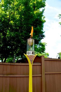 a yellow fire hydrant sitting in the middle of a yard next to a fence