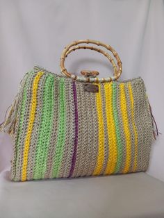 This bag is crocheted entirely by hand. The handle is made of bamboo wood and the internal lining, made of very resistant fabric, has two large pockets. The bag is closed by a wooden button, inserted into a loop. The bag is decorated on the side with two tassels. This is a very roomy, unique and durable bag; It will give a touch of class to your summer clothing. Measures: - Height without handle: 34 cm - Width: 42cm - Depth: 10 cm - Handle height: 14 cm (Please allow 1-2cm size difference since Natural Jute Crochet Bag With Bamboo Handle, Natural Color Jute Crochet Bag With Bamboo Handle, Summer Crochet Jute Bag With Bamboo Handle, Crochet Jute, Size Difference, Top Handle Bags, Jute Rope, Bamboo Handles, Summer Maxi