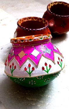 two colorful pots sitting on top of a white floor