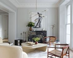 a living room filled with furniture and a painting on the wall above a fire place