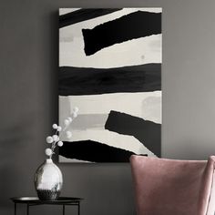 a black and white painting on the wall next to a pink chair in a living room