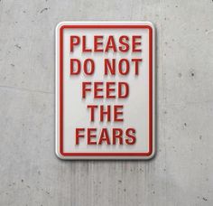 a red and white sign that says please do not feed the fears on it