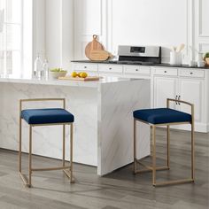 two blue stools sitting in front of a marble counter top with an oven and microwave