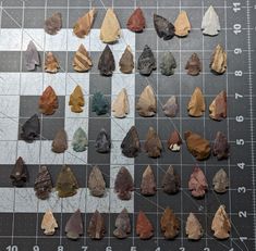 a group of rocks sitting on top of a checkerboard table next to a ruler