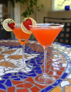 two martinis with strawberries on the rim