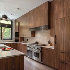 a kitchen with wooden cabinets and stainless steel appliances, along with an island in the middle