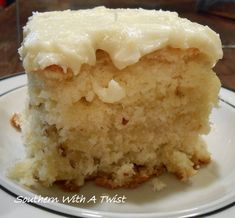 a close up of a piece of cake on a plate with white frosting and nuts