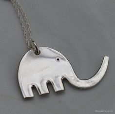 an elephant pendant is shown on a chain