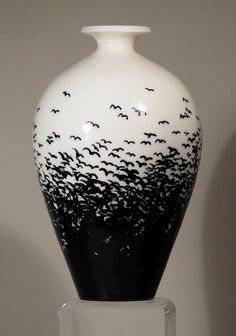 a black and white vase with birds on it