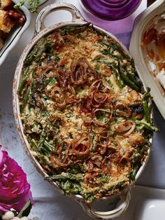 a casserole dish with onions, green beans and other foods on the side