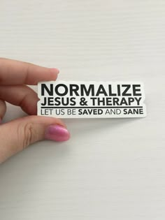 someone holding up a sticker that says normalize jesus & therapy let us be saved and sane