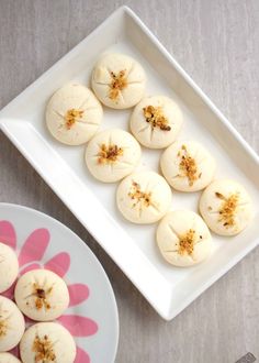 some food is sitting on a white plate and next to a pink flower shaped dish