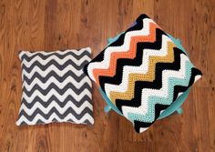 two pillows sitting on top of a wooden floor next to each other, one has a black and white zigzag pattern