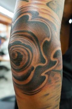 a man with a tattoo on his arm that has swirls in the shape of circles