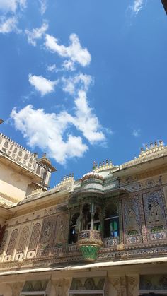 an ornate balcony with blue sky and clouds in the background