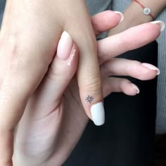 two hands holding each other with white nail polish on them