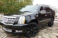 a black suv is parked on some rocks