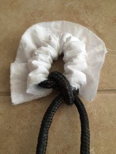 a black and white rope on the ground with a cloth wrapped around it's end