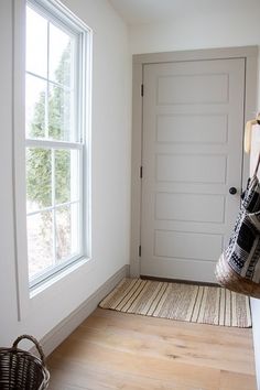 an empty room with a basket on the floor and a door in the wall behind it