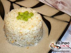 a close up of a plate of food with rice and green onions on the top