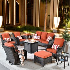 an outdoor seating area with orange cushions and pillows on the couches, coffee table and side tables