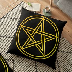 a black and yellow floor pillow with a pentagramil in the middle on it