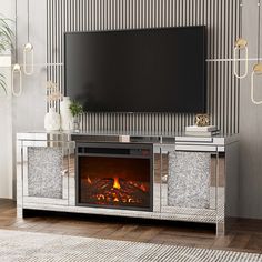 a living room with a fireplace and television on the wall in front of an entertainment center