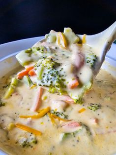 a white bowl filled with broccoli and cheese soup