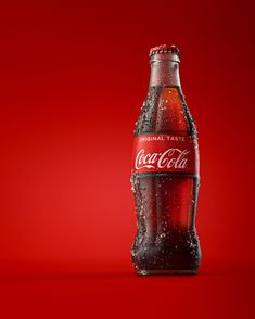 a bottle of coca cola on a red background