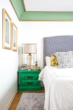 a bedroom with a bed, nightstand and pictures on the wall